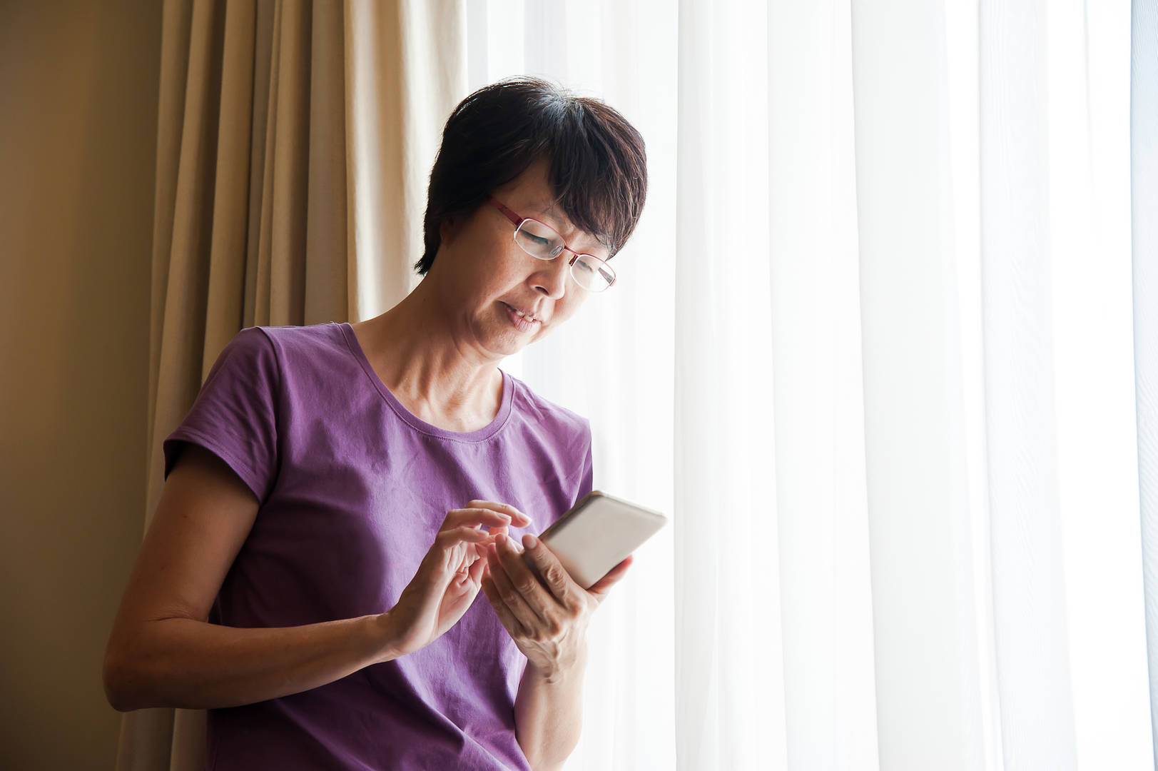 asian woman on smartphone at home