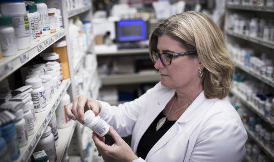 Pharmacist stocking bottles