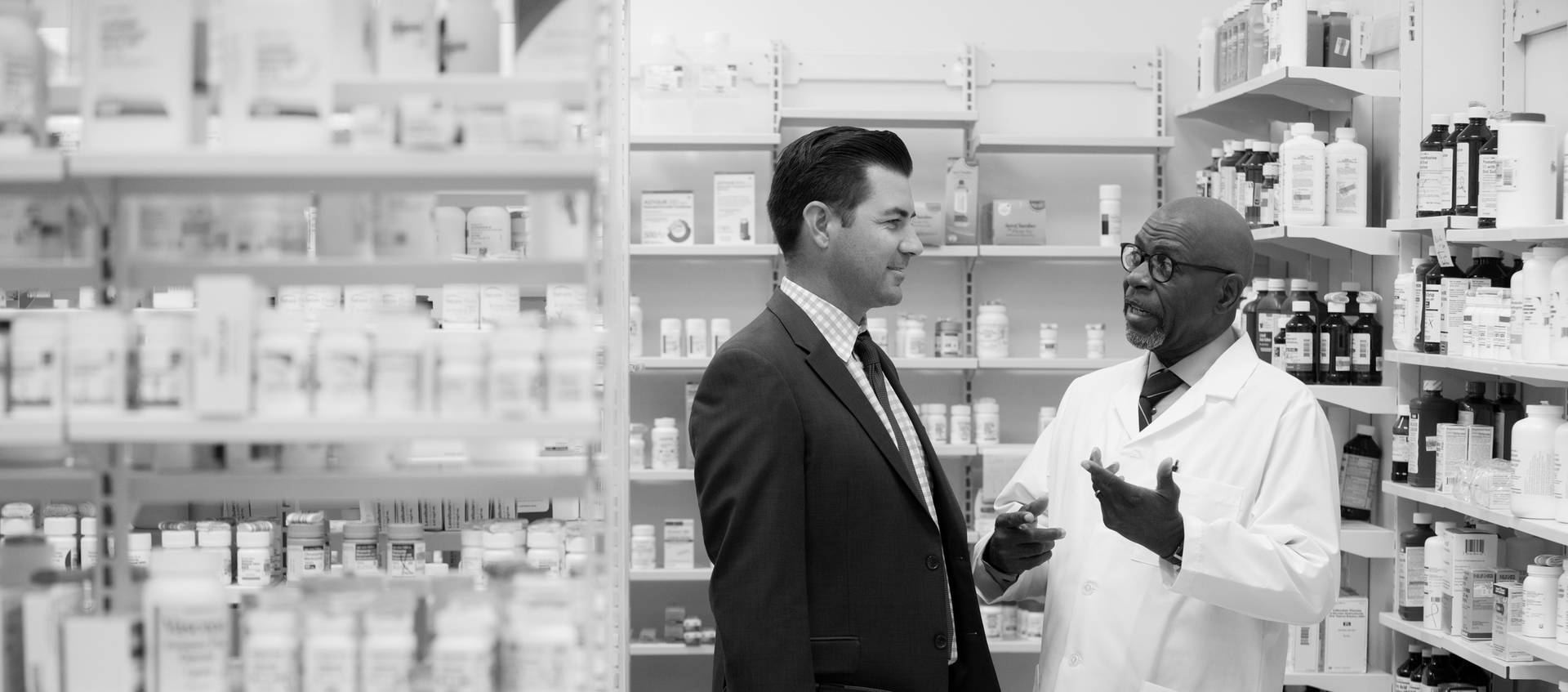 A pharmacy acquisition advisor listens to a pharmacy seller share details about his business