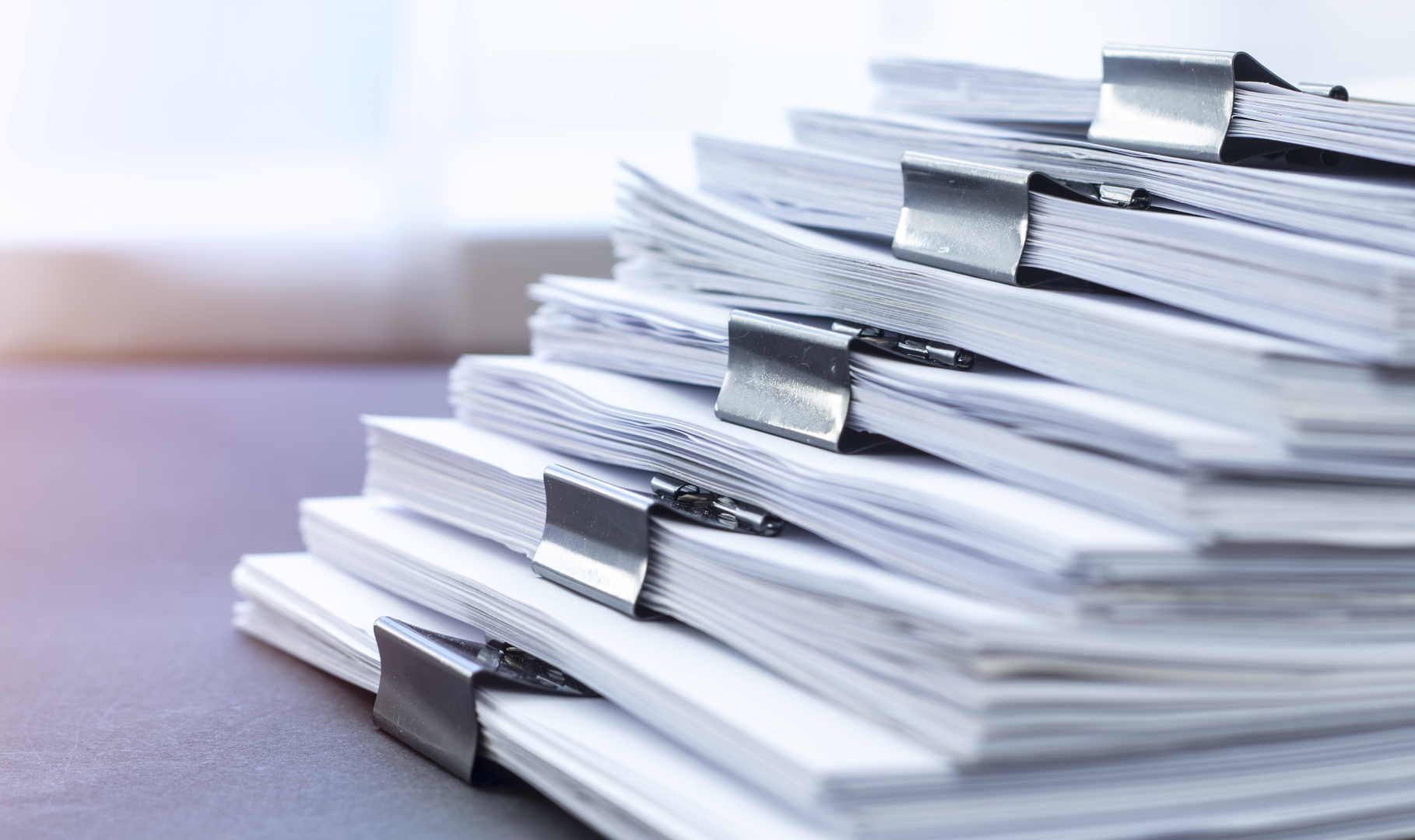 A stack of financial documents organized into packets with binder clips