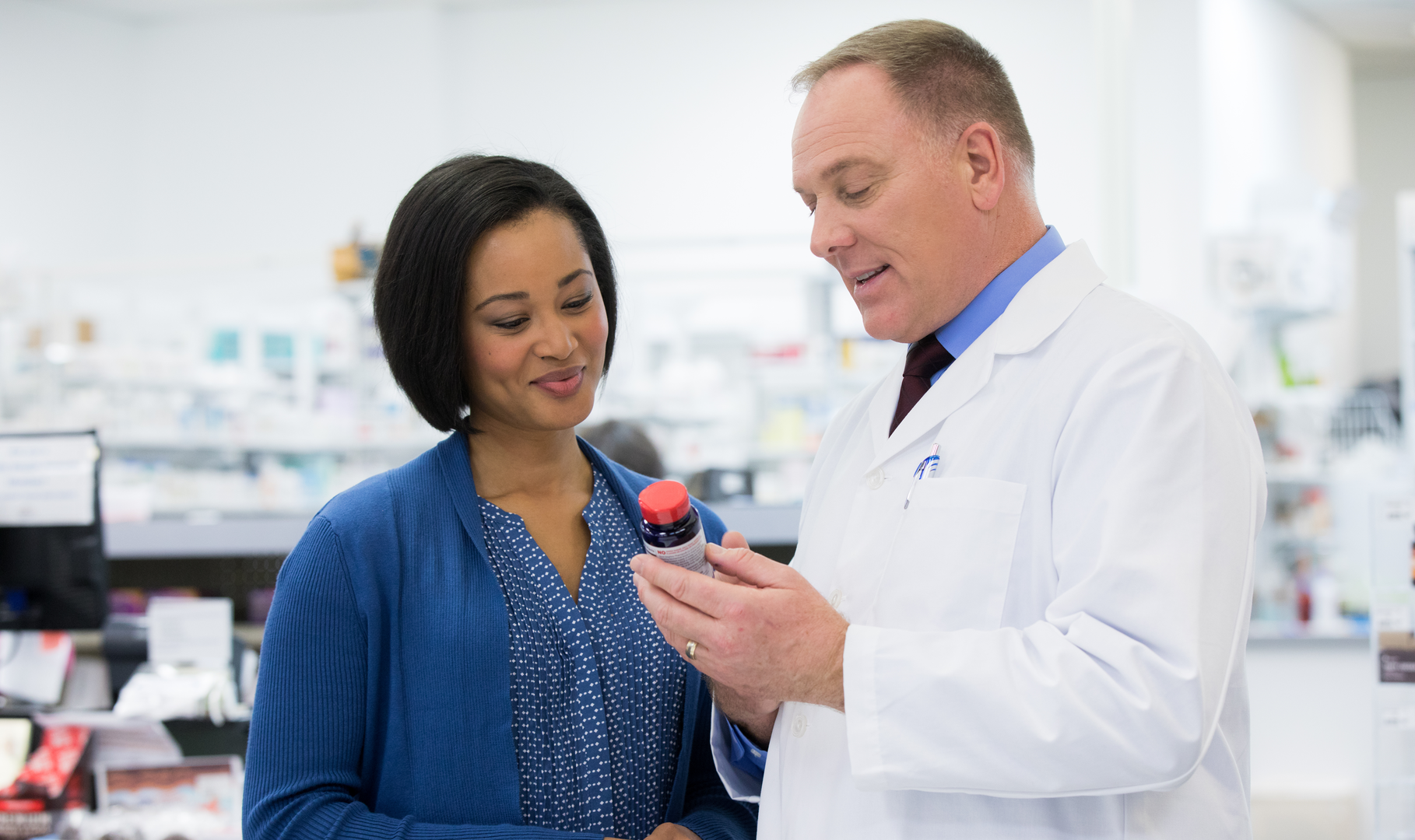 A pharmacist educating a patient on vitamin supplements