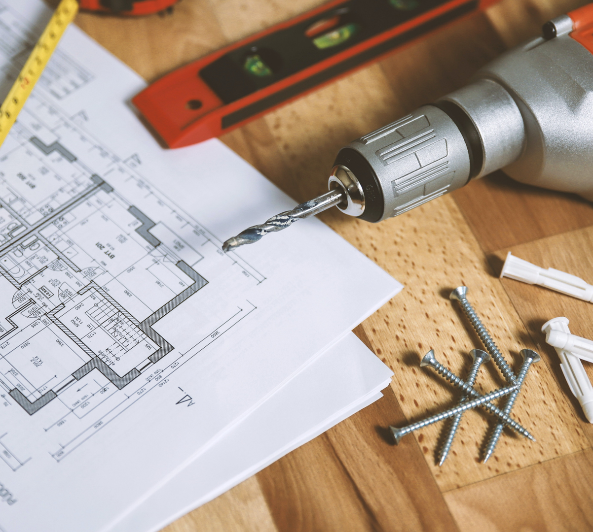 Blueprint and tools laid out on a table in preparation for an independent pharmacy renovation