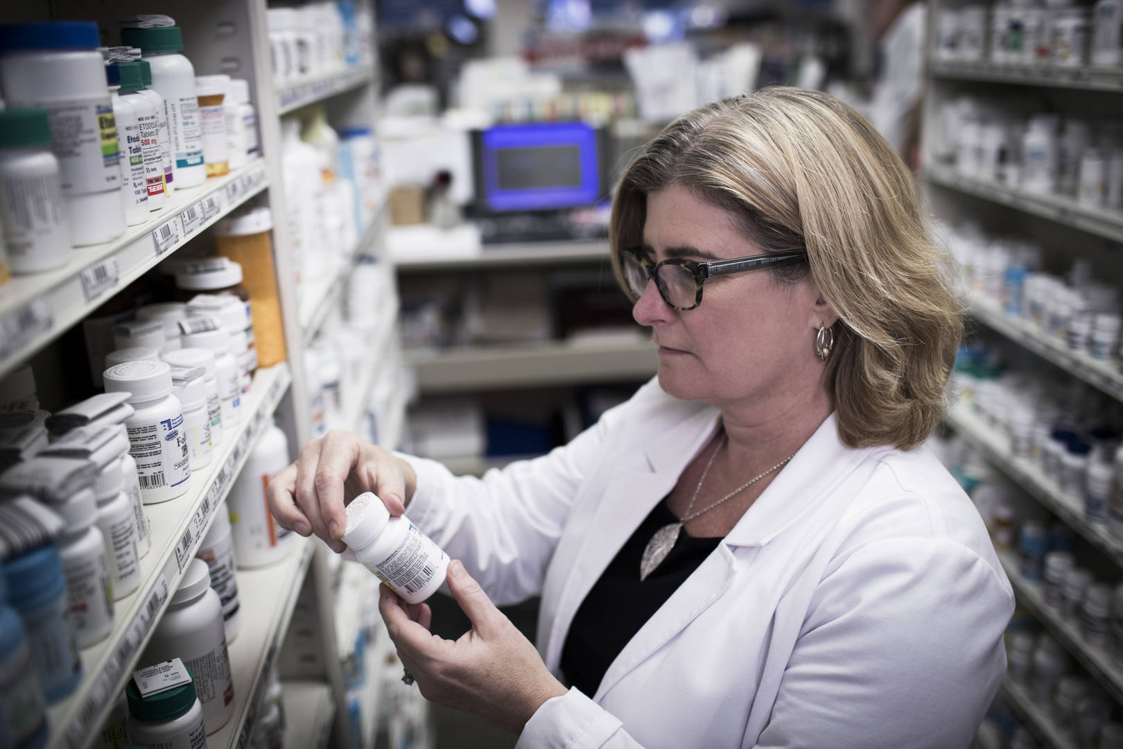 Pharmacist stocking bottles